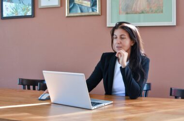 Business owner researching outsourcing options on a laptop at a desk