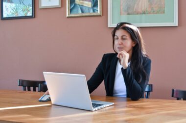 Business owner researching outsourcing options on a laptop at a desk